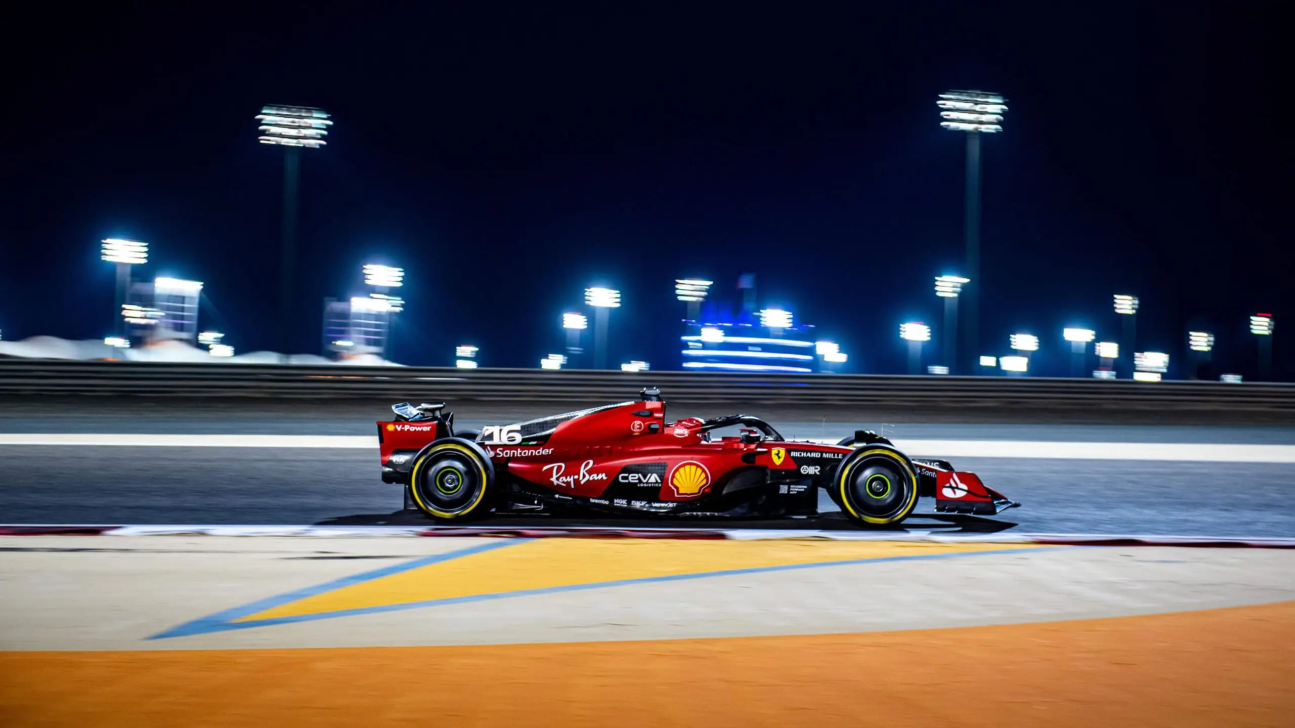 Formula 1 car under floodlights on a night circuit